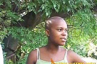 Man dominates over naked black slave with bald head right in backyard