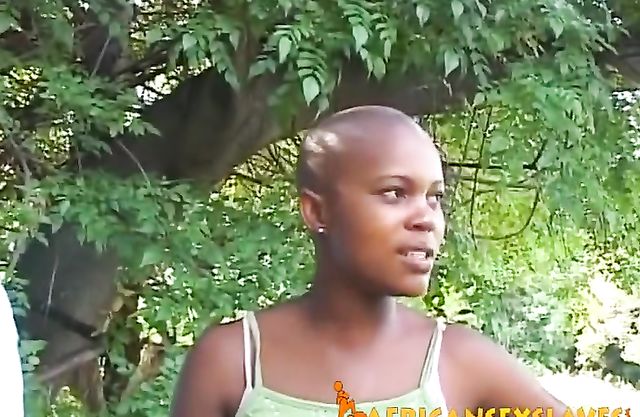 Man dominates over naked black slave with bald head right in backyard