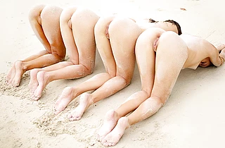 Four beautiful teen models enjoy being naked at the beach