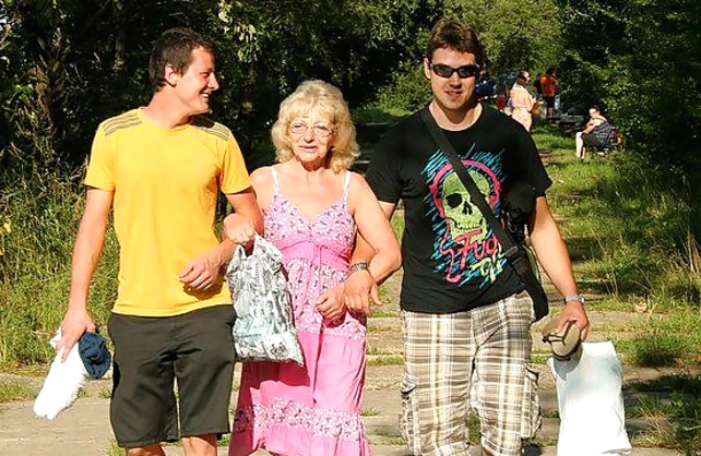 Young guys pick up an old woman and have naked sex in the forest