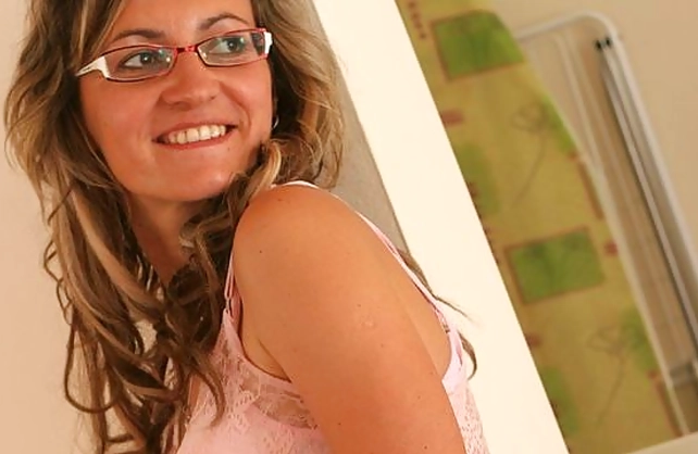 Nerdy MILF in white stockings fingers naked cunt sitting on the floor
