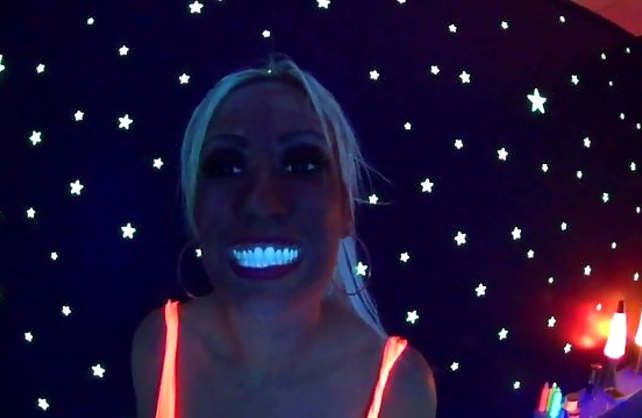 Lesbian girls with naked breasts have fun with fluorescent paint