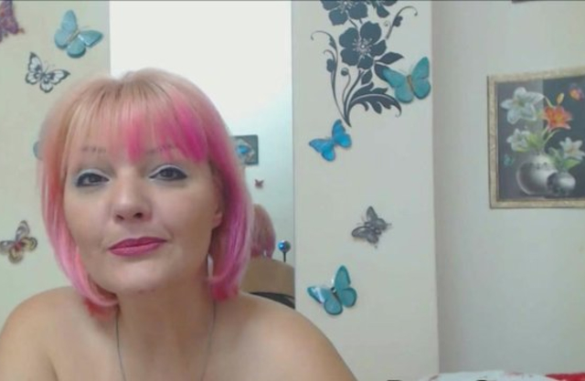 Naked girl over forty with pink hair performs a sexy webcam show