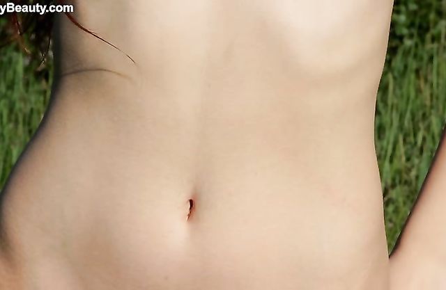 Naked redhead girl with small tits enjoys playing a naughty solo near the water