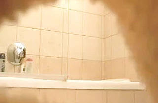 Sexy looking honey takes off her thong to get naked before taking a shower