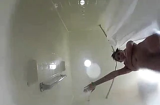 Naked amateur babe is filmed in the hotel room's shower when she masturbates